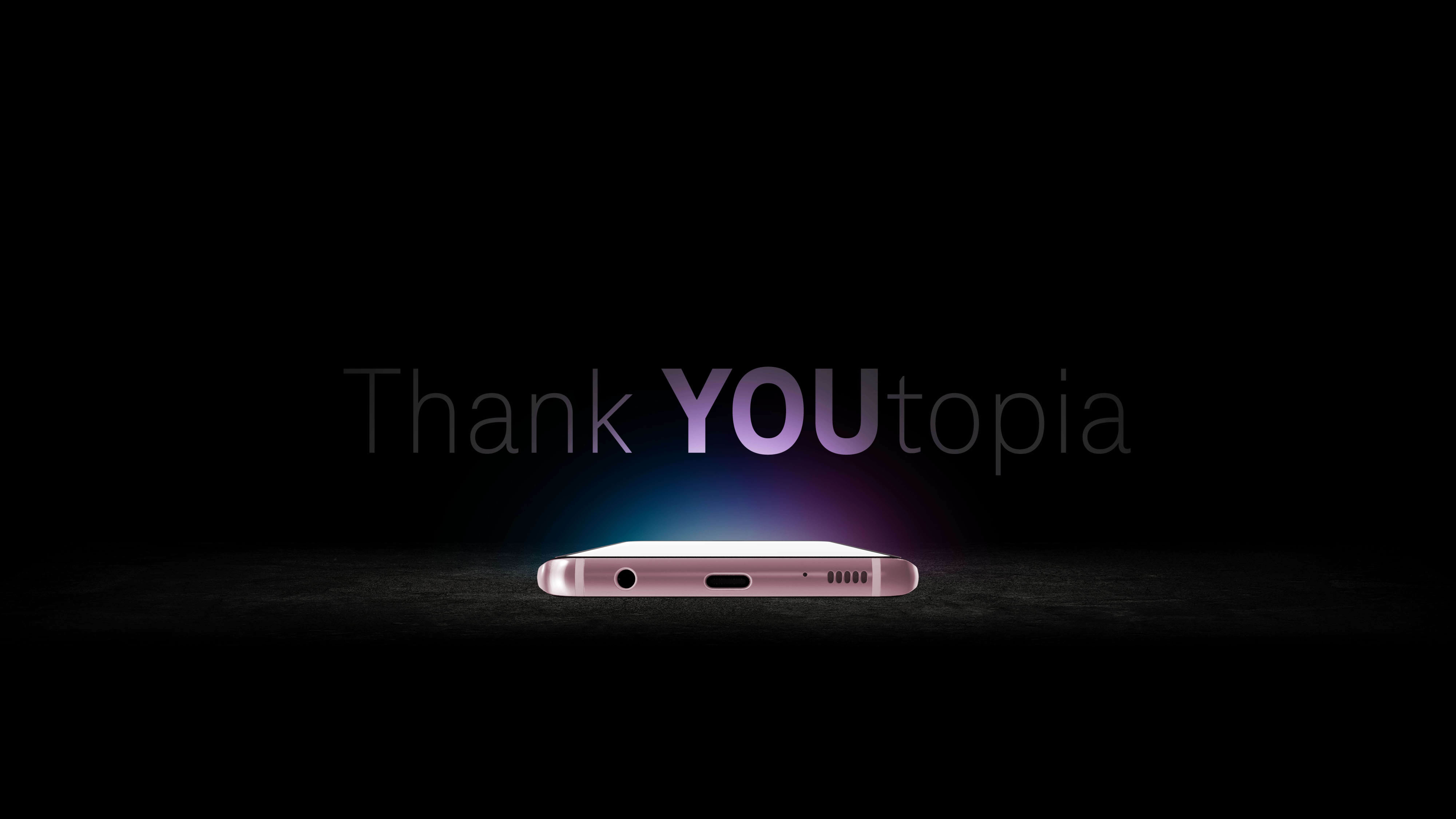 Thank YOUtopia direction: phone glowing on a dark surface with purple gradient text
